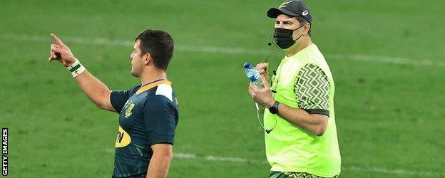 Rassie Erasmus acting as a waterboy during a game