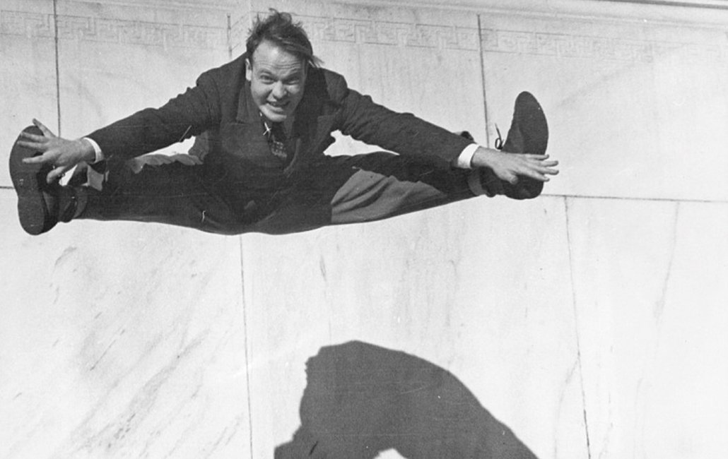 black and white image of Fremont Davis jumping in the air and touching his toes