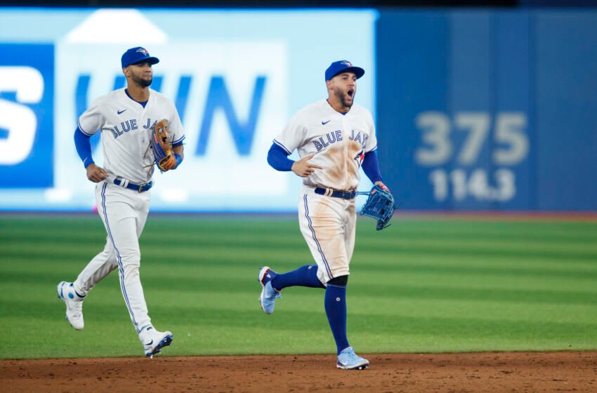TORONTO, ON - APRIL 08: Lourdes Gurriel Jr. #13 and George Springer #4 of the Toronto Blue Jays run to the infield after their MLB game victory against the Texas Rangers on Opening Day at Rogers Centre on April 8, 2022 in Toronto, Canada. (Photo by Cole Burston/Getty Images)