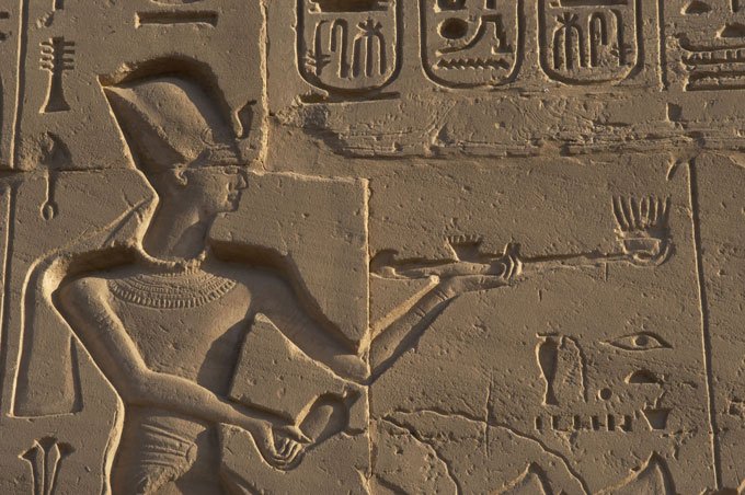 wall carving showing pharaoh Ramses II holding an incense burner