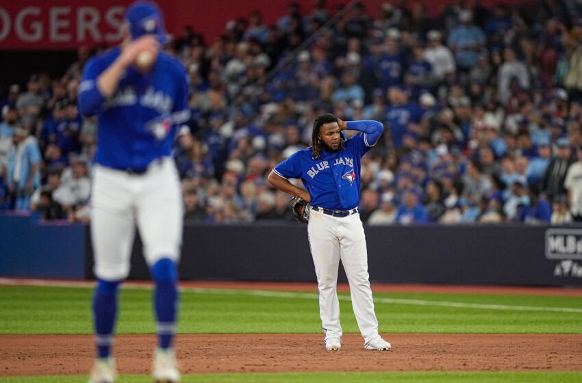 Oct 8, 2022; Toronto, Ontario, CAN; Toronto Blue Jays first baseman Vladimir Guerrero Jr. (27) looks on as relief pitcher Adam Cimber (90) takes the mound in the ninth inning against the Seattle Mariners during game two of the Wild Card series for the 2022 MLB Playoffs at Rogers Centre. Mandatory Credit: John E. Sokolowski-USA TODAY Sports